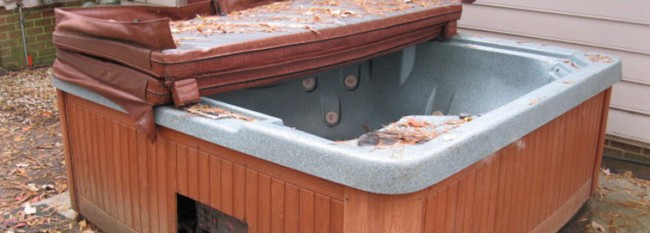 Old hot tub outside with leaves inside. Mike & Dad's Hauling provides hot tub removal services in Vancouver WA.