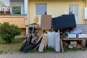 A junk pile in the front of a Vancouver home. Call or contact Mike & Dad's Hauling if you have unwanted junk removal needs.